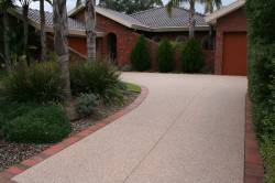 Light Aggregate concrete driveway with red brick edge